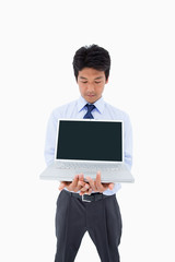 Portrait of a businessman showing a laptop