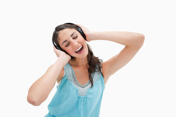 Naklejka premium Woman singing while listening to music