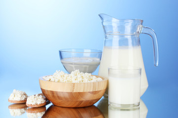 Milk, sour cream and cottage cheese on blue background