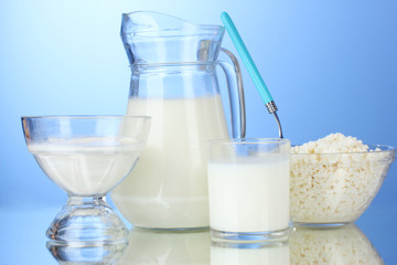 Milk, sour cream and cottage cheese on blue background