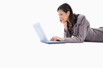 Side view of lying woman using laptop