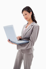 Side view of businesswoman standing with laptop