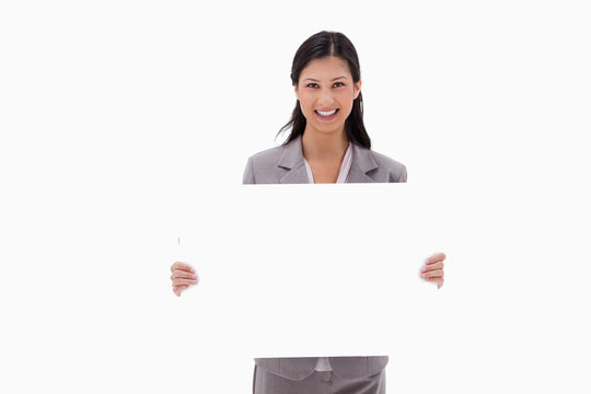 Smiling businesswoman with blank sign board