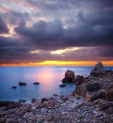 Panele Szklane Podświetlane  Kamienie morskie o zachodzie słońca