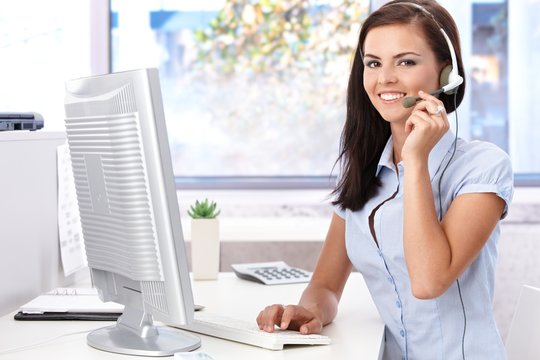 Happy female sitting at desk in bright office