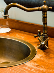 Vintage bathroom faucet on brass water basin