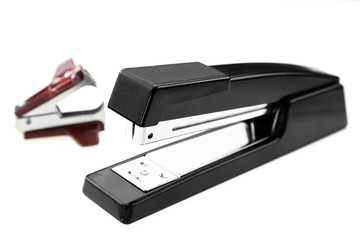 Stapler and staple remover on white background