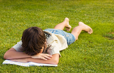 boy sleeping over boring book