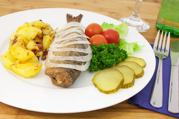 Brathering mit Zwiebelringen und Bratkartoffeln