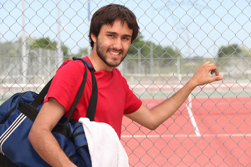 Tennis player stood by outdoor court