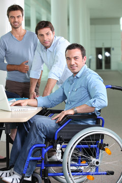 Man in a wheelchair pictured with colleagues