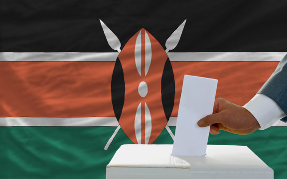 man voting on elections in kenya in front of flag