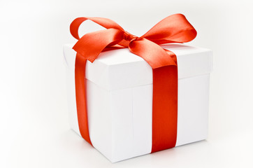 Single white gift box with red ribbon