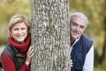 Married couple leaning against tree