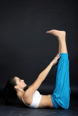 Obraz premium The young beautiful girl in bright clothes is engaged in gymnast