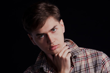 Obraz premium Portrait of a handsome young man in a plaid shirt