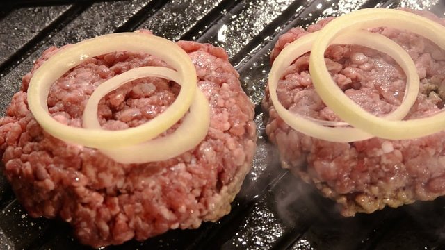 fast food, hamburger alla piastra con cipolla