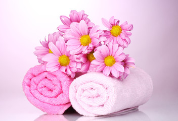 Obraz na płótnie Canvas ręczniki i piękne kwiaty na różowym tle