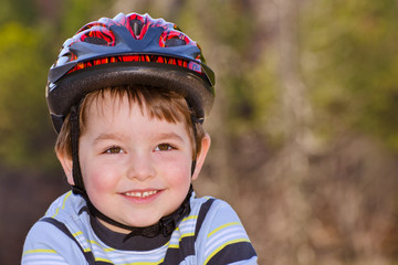 Boy riding bike with safety helmet outdoors at park