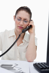 Portrait of a young manager making a phone call while looking at