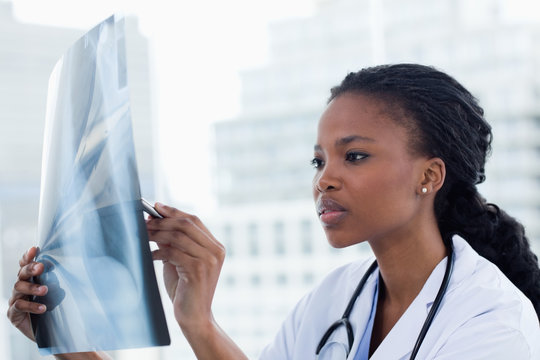 Focused female doctor looking at a set of X-rays