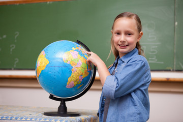 Smiling schoolgirl looking at a globe