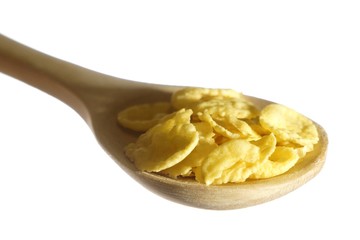 Cornflakes in wooden spoon, white background