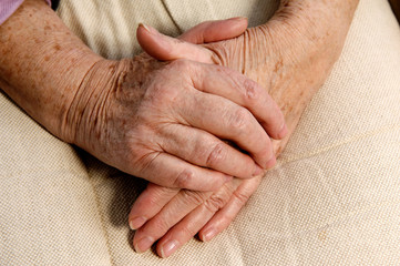 gefaltene Hände einer Seniorin