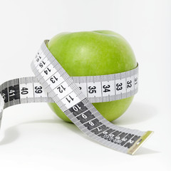 Fresh green apple with measuring tape