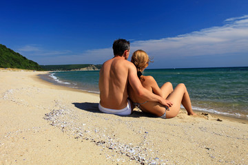 Rear view of young caucasian couple at the beach
