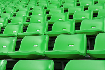 Naklejka premium Green Empty plastic seats at stadium