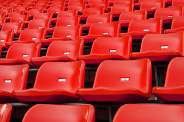 Naklejka premium Red Empty plastic seats at stadium