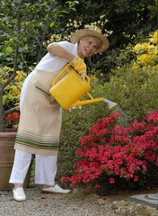 Mujer adulta haciendo el jardín regando plantas.