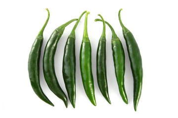Row of green chili on white background.