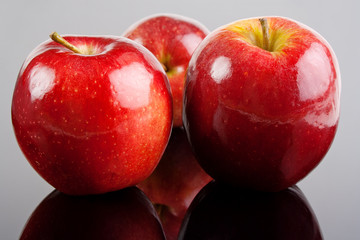 Shiny red apple fruits on glossy background
