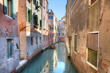 Fototapeta na wymiar Small canal among houses. Venice, Italy.