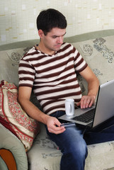 young guy with a laptop on the couch