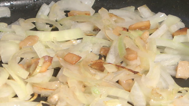 Onions are fried with fat a close up.