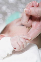 mother touch hand with newborn