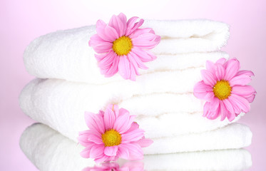 Fototapeta na wymiar towels and beautiful flowers on pink background