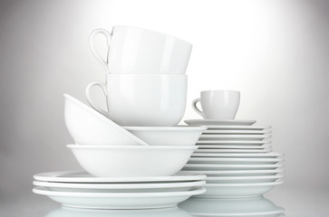 empty bowls, plates and cups on gray background