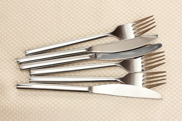 Forks and knives on a beige tablecloth