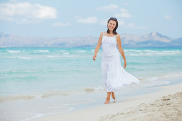 Fototapeta na wymiar young woman walking near blue sea.