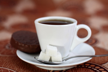 Coffee cup from coffee, cookies, a spoon and sugar