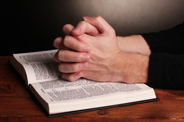 Naklejka premium Hands folded in prayer over a Holy bible