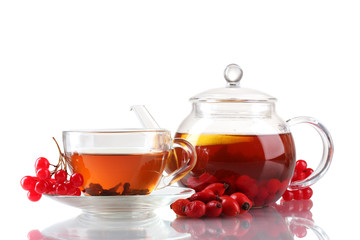 Glass teapot and cup with black viburnum hips tea isolated