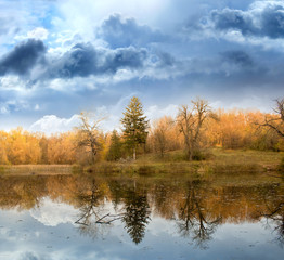 Autumn landscape against the terrible sky and the river