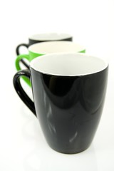 Three coffee cups. Green cup in the center