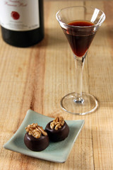 ein glas port mit zwei pralinen