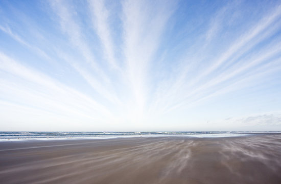 Parallel lines of sand and clouds on a windy beach © Matauw